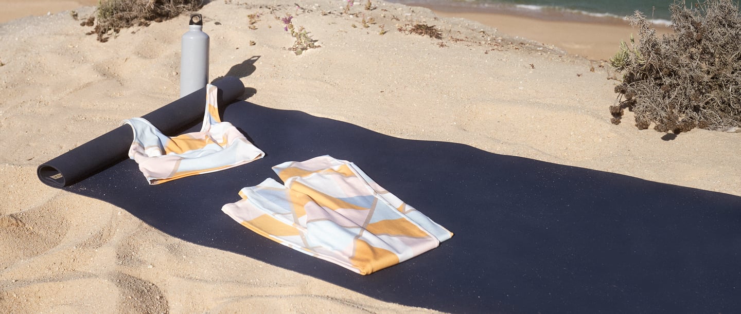Tapis de yoga avec vêtements de yoga CALIDA sur la plage