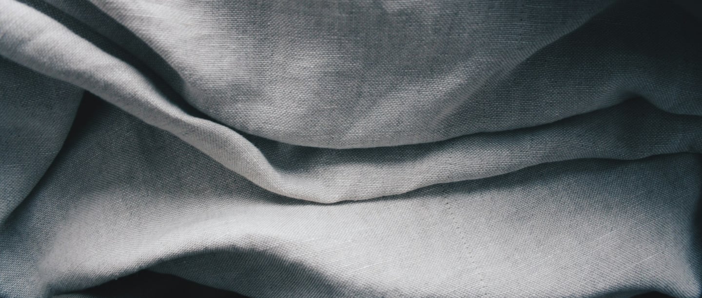 Close-up of folded linen fabric in various shades of grey.