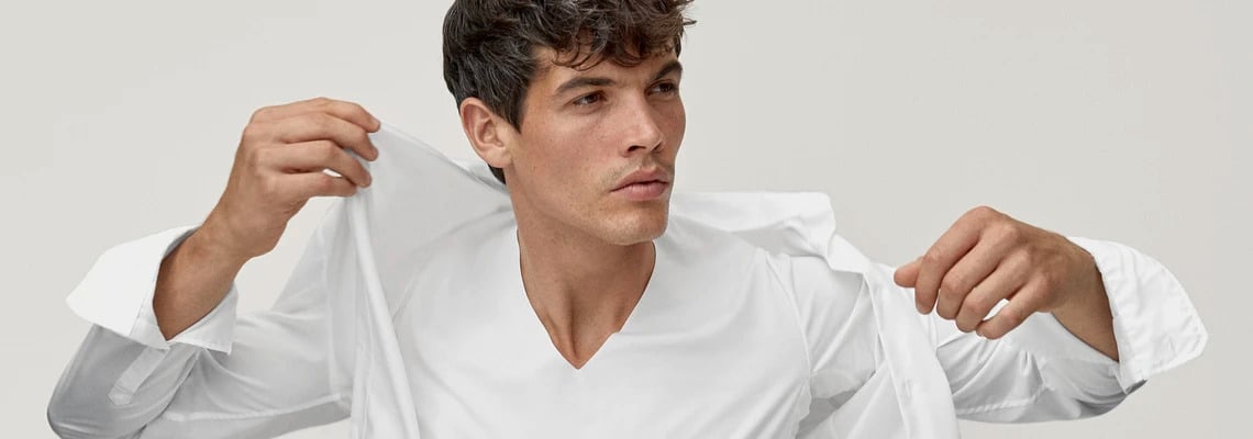 Man wears a white undershirt from Calida from the series 'Fresh Cotton' and over it a white shirt
