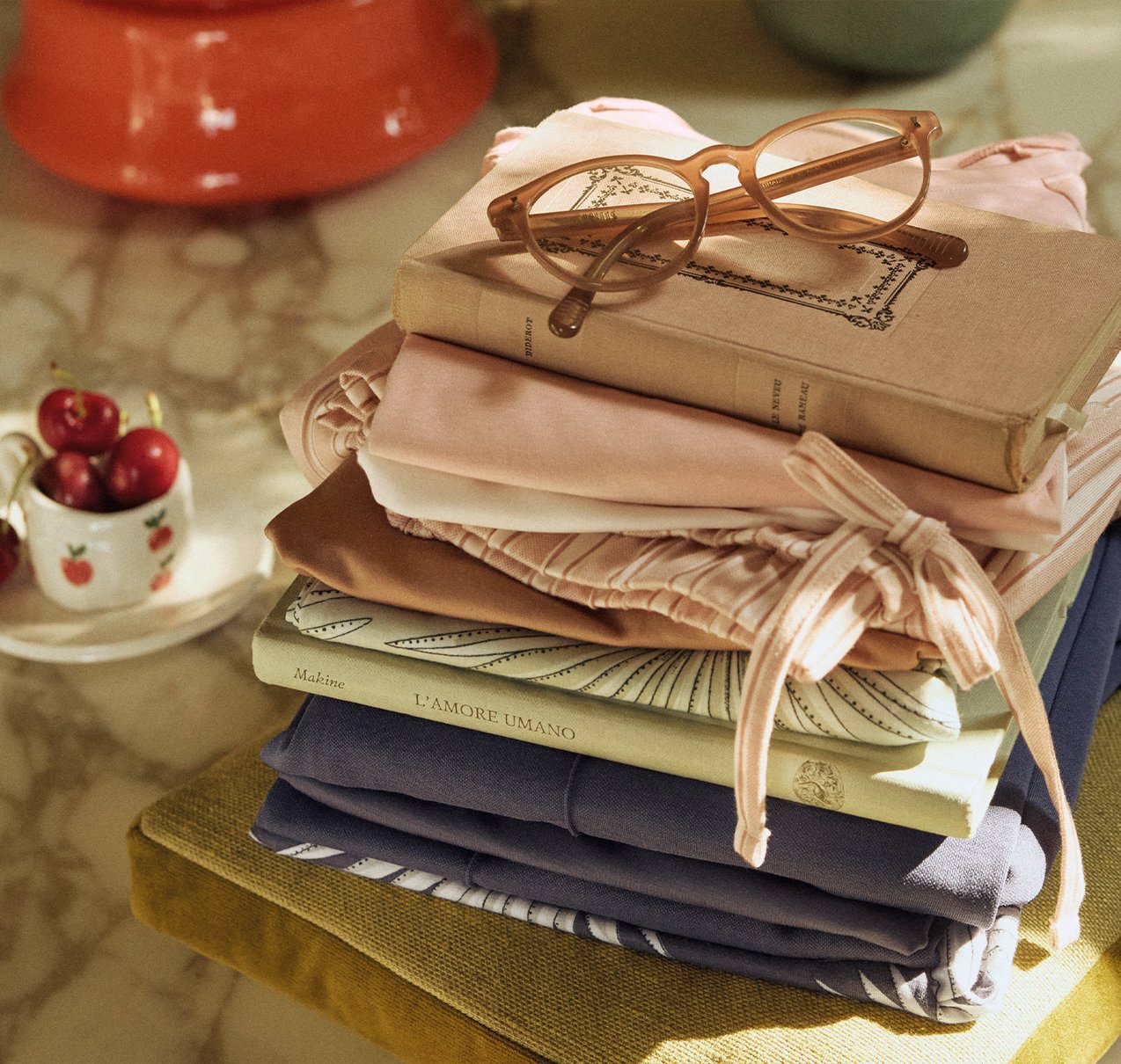 Auf einem Tisch liegt zusammengefaltete Calida Nachtwäsche zwischen einigen Büchern