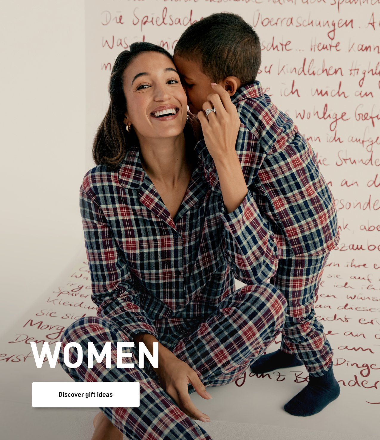 Model wears a plaid flannel pajama set matching with a child and presents winter nightwear for the whole family.