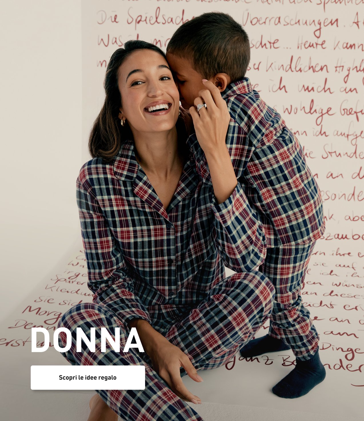 Il modello indossa un pigiama di flanella a quadri coordinato con il bambino e presenta abbigliamento da notte invernale per tutta la famiglia.