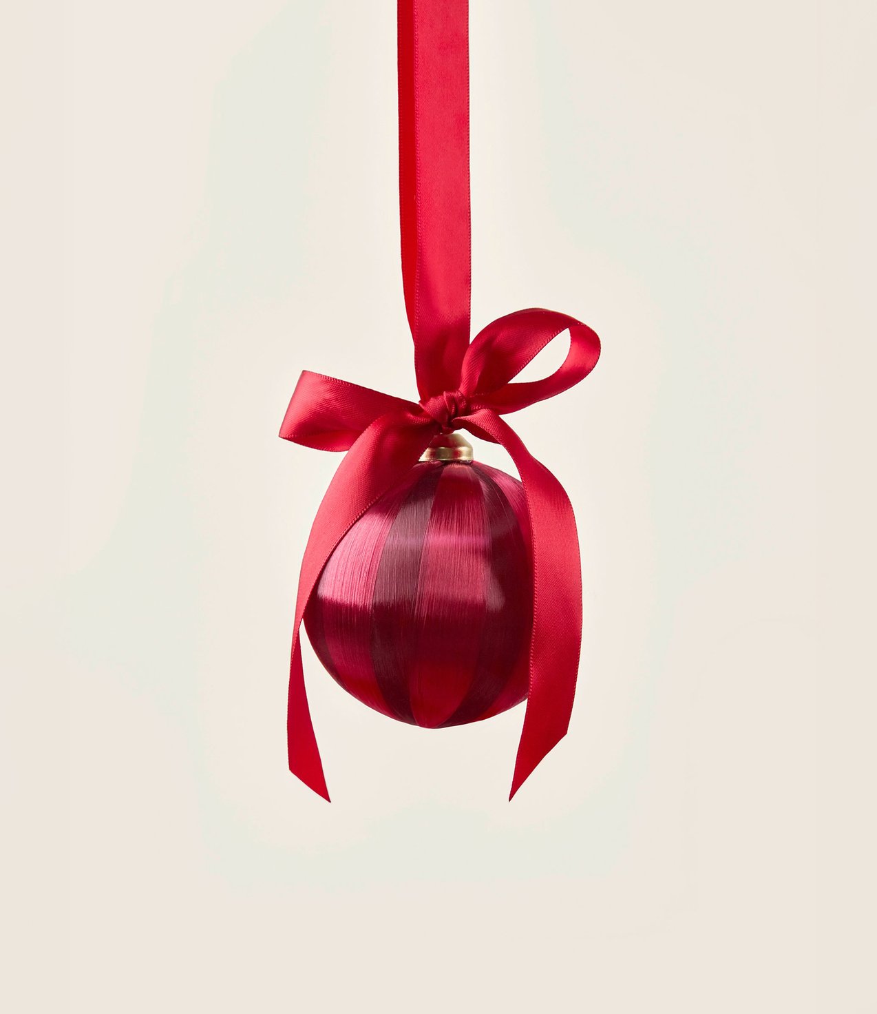 Festive Christmas ball in red with decorative bow as an atmospheric accessory for the gift season.