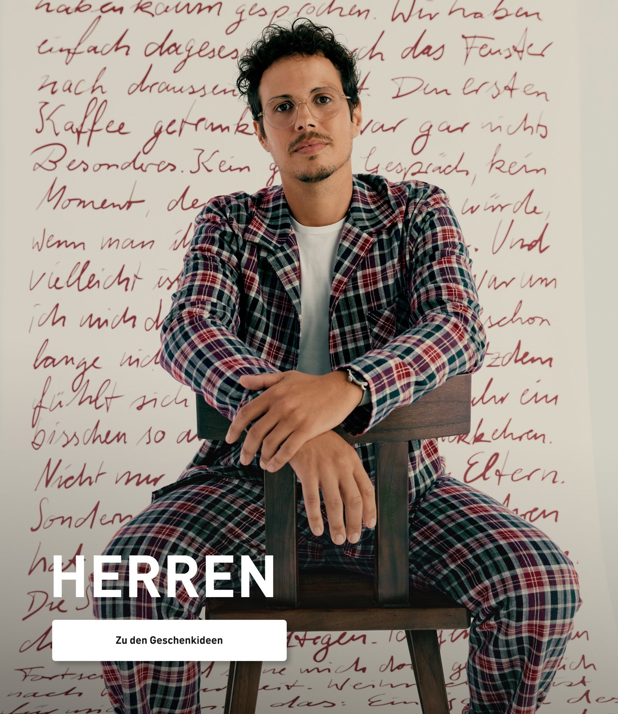 Model trägt einen karierten Flanell-Schlafanzug in Blau- und Burgundertönen und präsentiert einen klassischen Winterlook für entspannte Nächte.