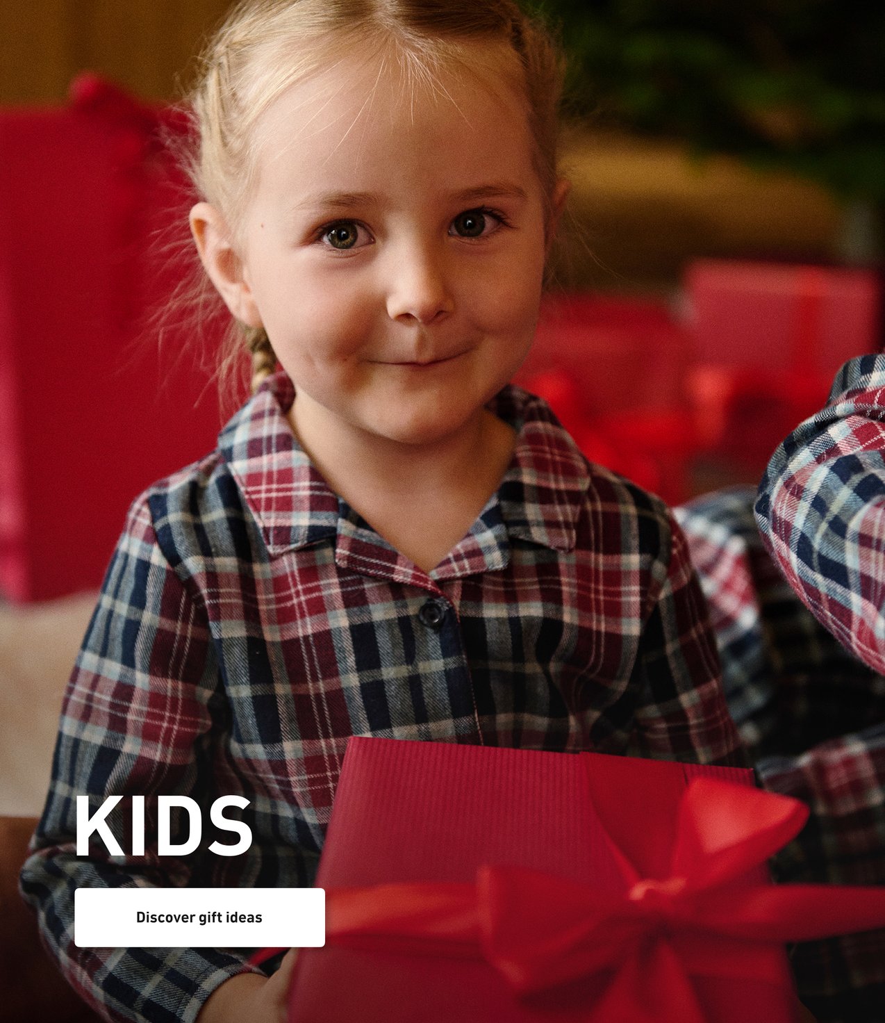 Children in Christmas pajamas with gifts in their hands.