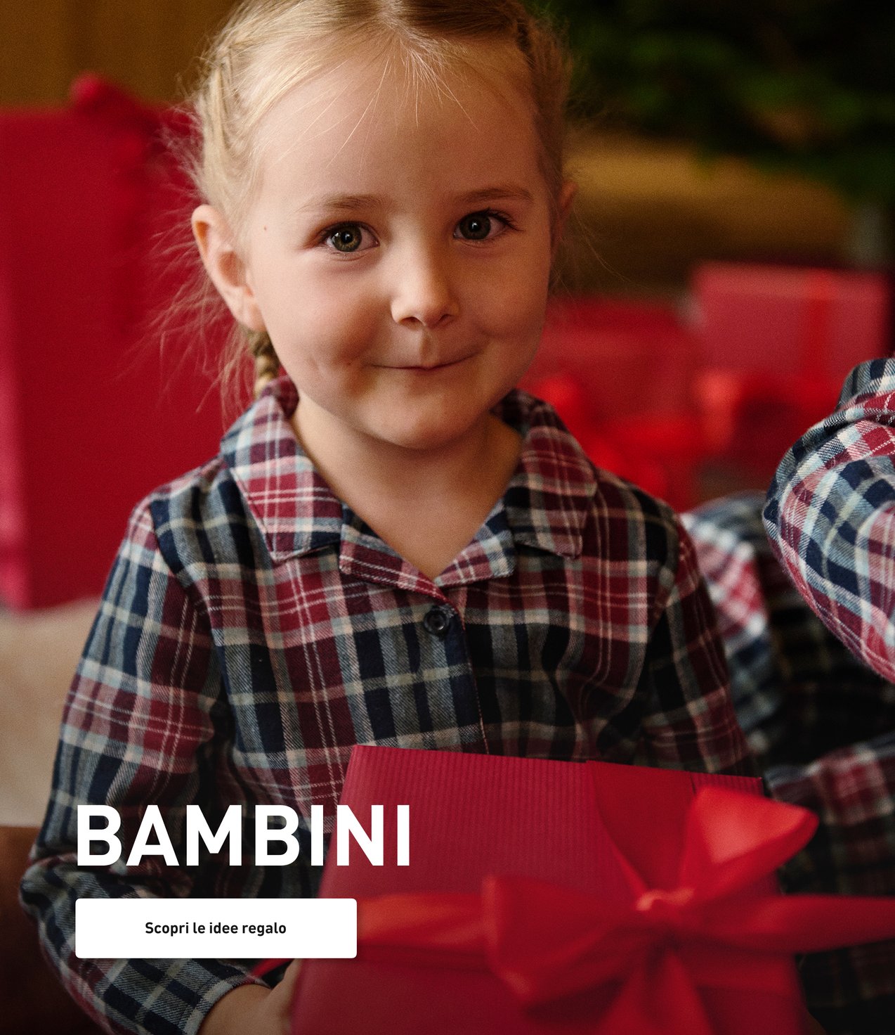 Bambini in pigiami di Natale con regali in mano.