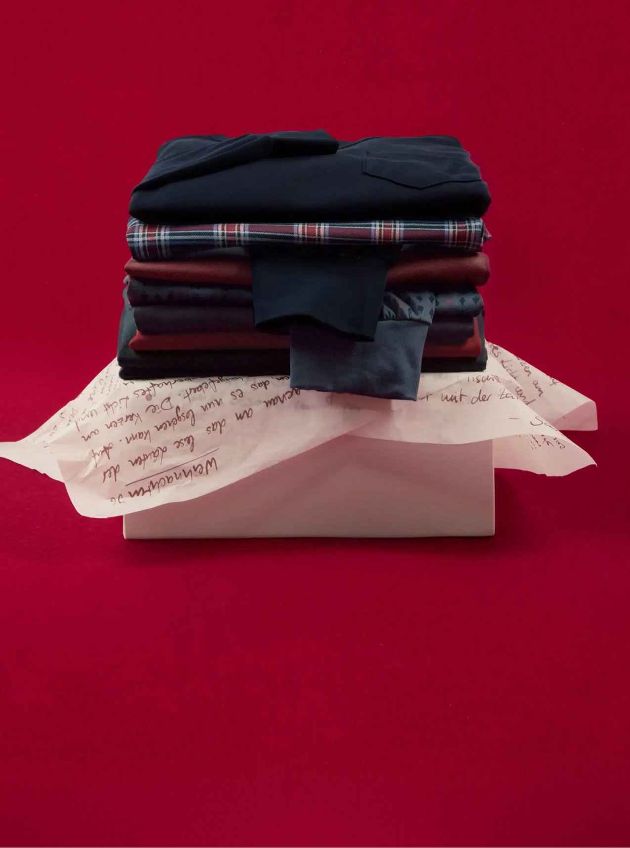 Selection of coordinated nightwear and loungewear sets, stacked and festively presented.