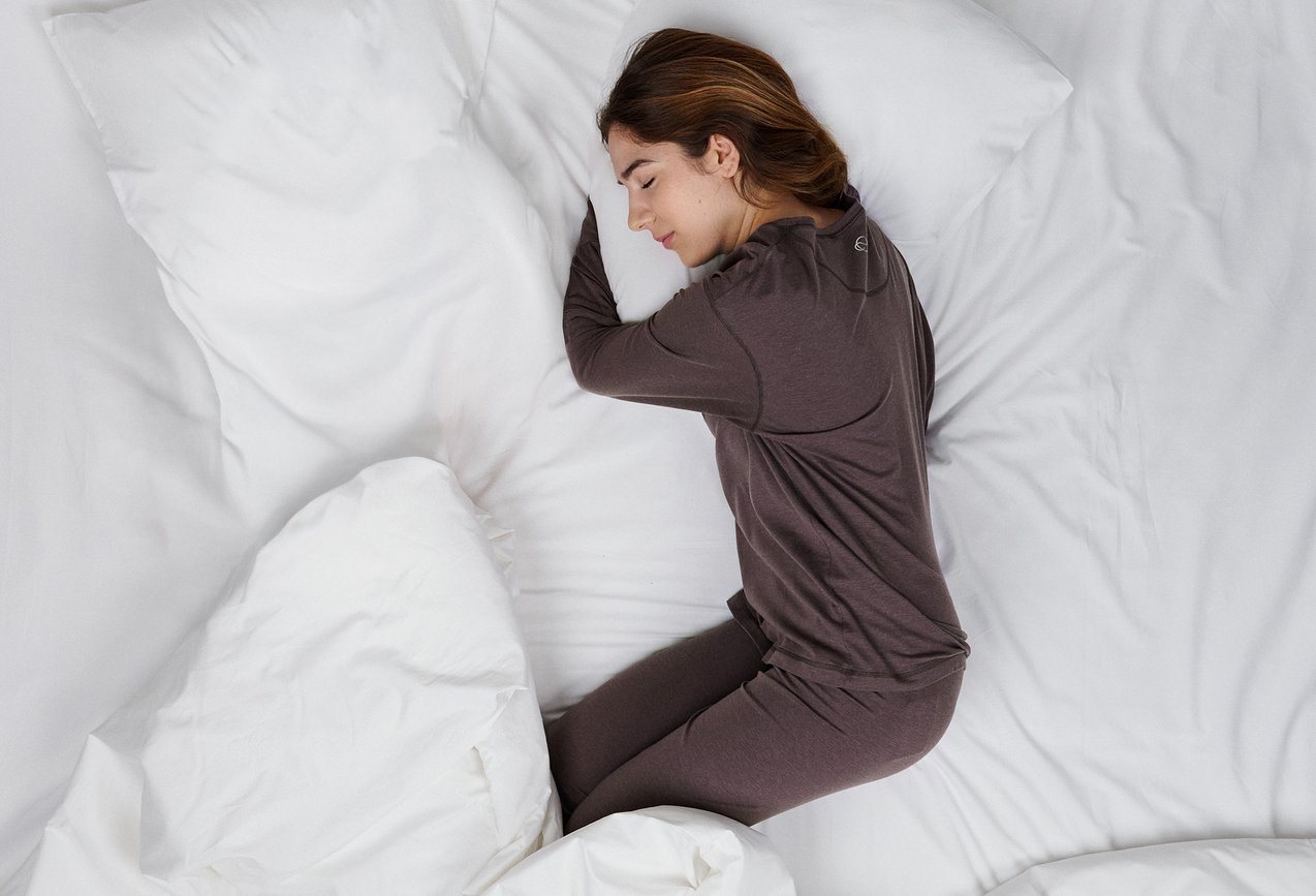 The lady is wearing pyjamas from the DEEPSLEEPWEAR Warming range in a soft brown colour.