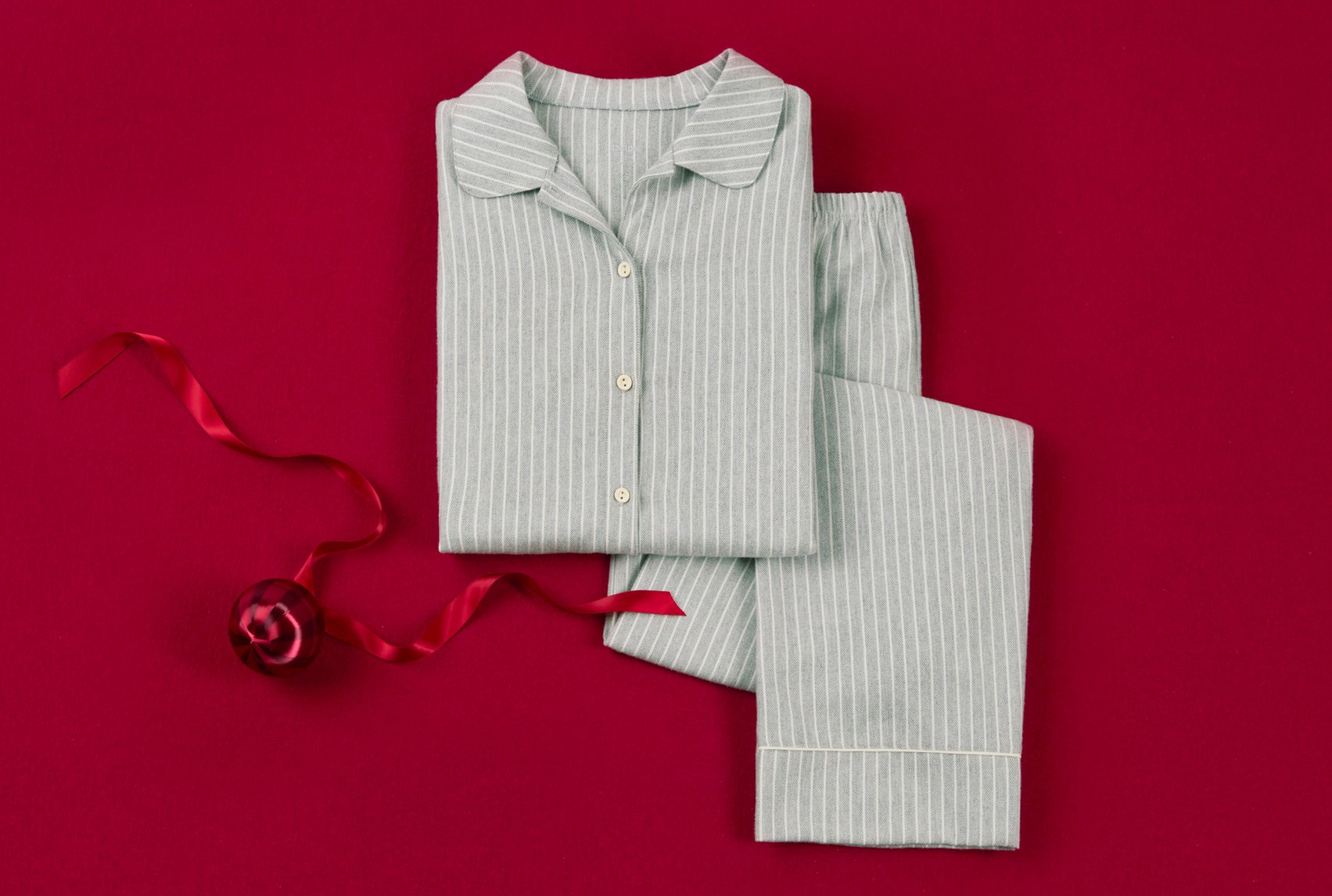 Classic cotton pajamas with a fine stripe pattern, decoratively presented on a festive background.