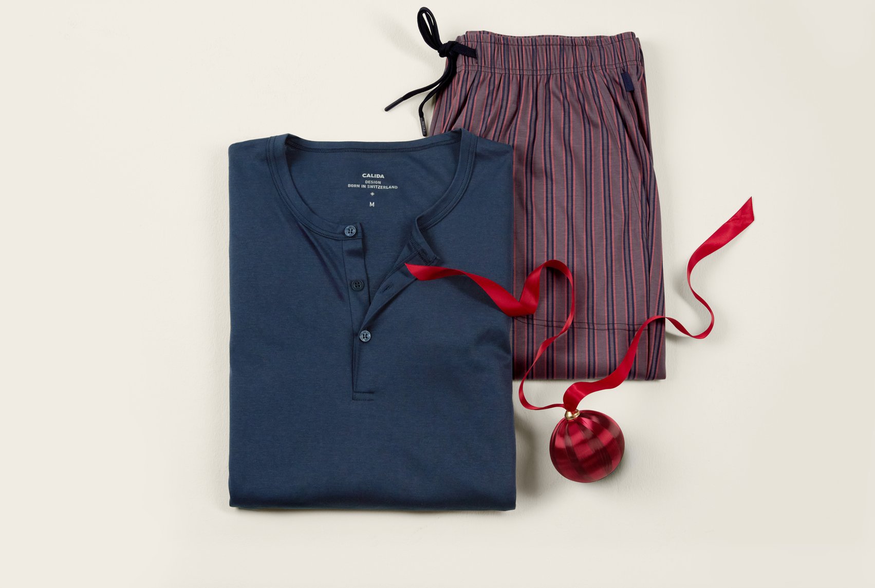 Sleep shirt in blue with matching striped sleep pants, decoratively arranged as a gift idea.