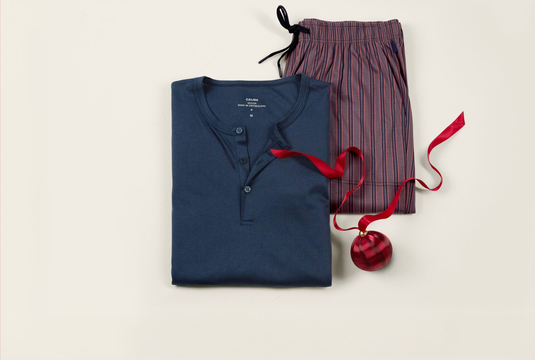 Sleep shirt in blue with matching striped sleep pants, decoratively arranged as a gift idea.