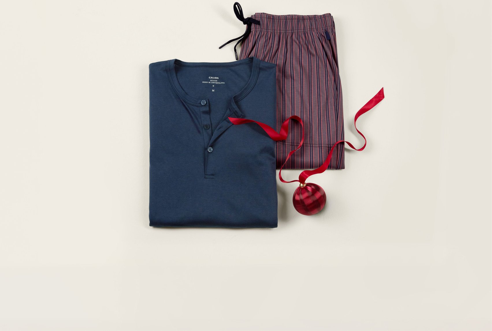 Sleep shirt in blue with matching striped sleep pants, decoratively arranged as a gift idea.