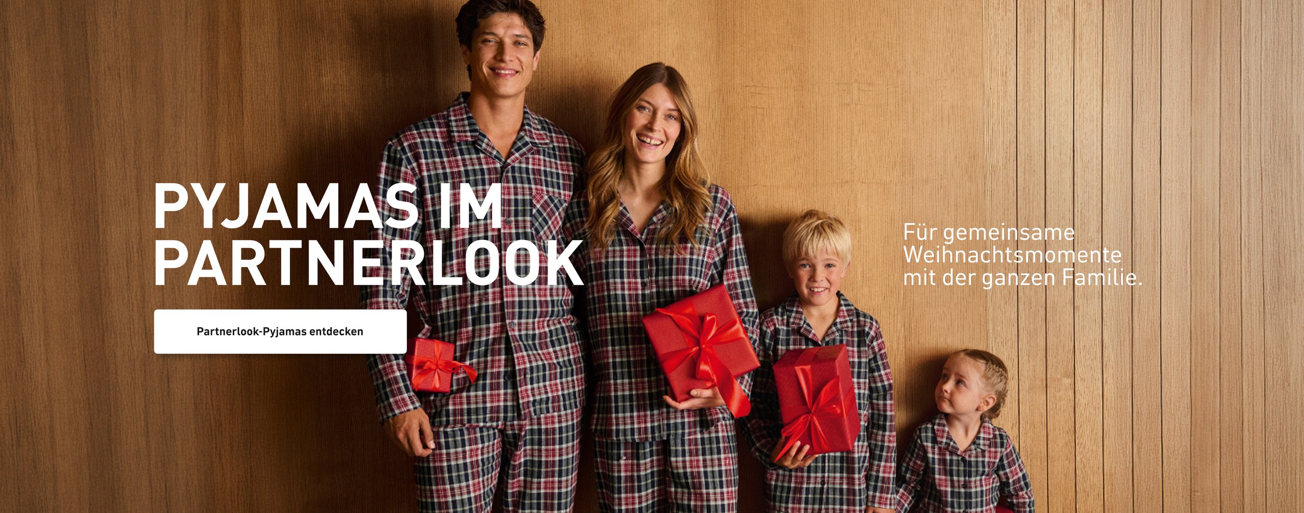 Pyjamas im Partnerlook. Familie in abgestimmten Flanell-Pyjamas mit Karomuster, inszeniert für gemeinsame Weihnachtsmomente.