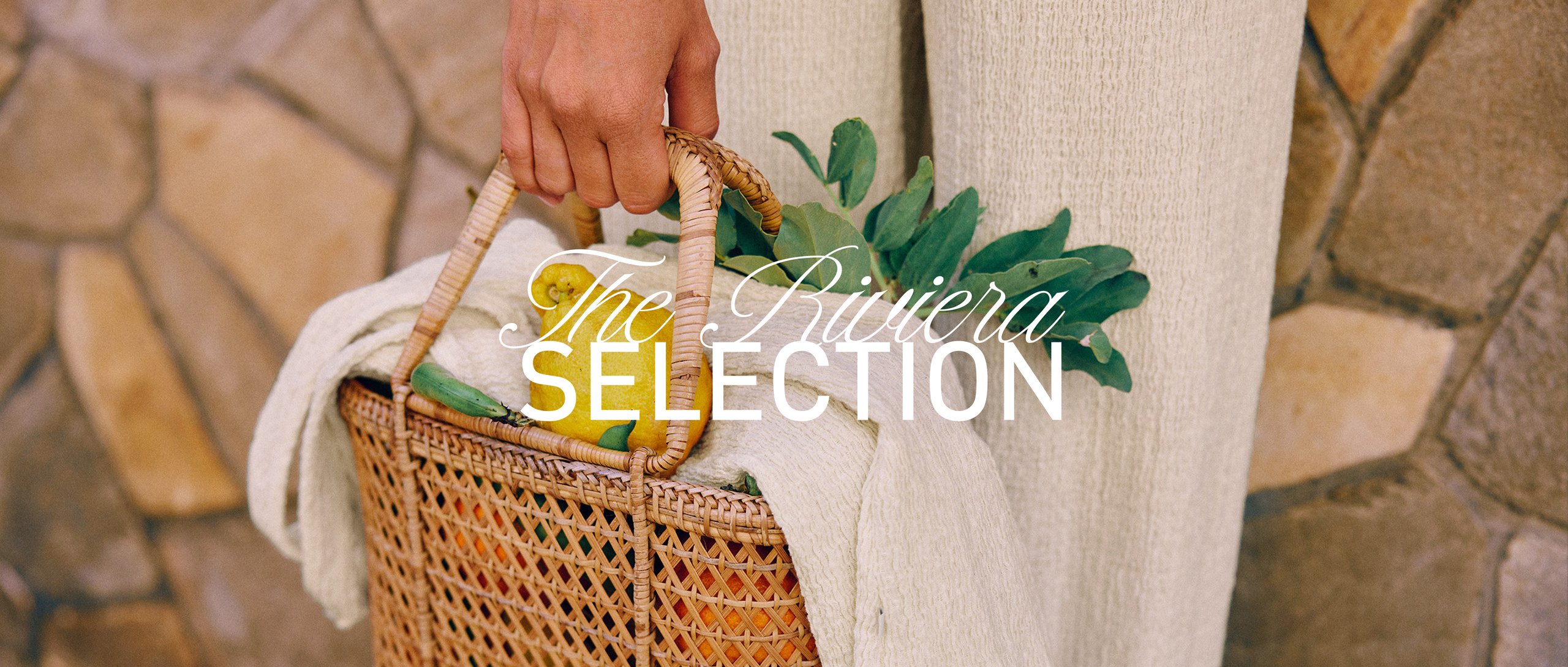 A close up from a woman holding a basket-bag with lemons. She is wearing a white bottom from the riviera selection.
