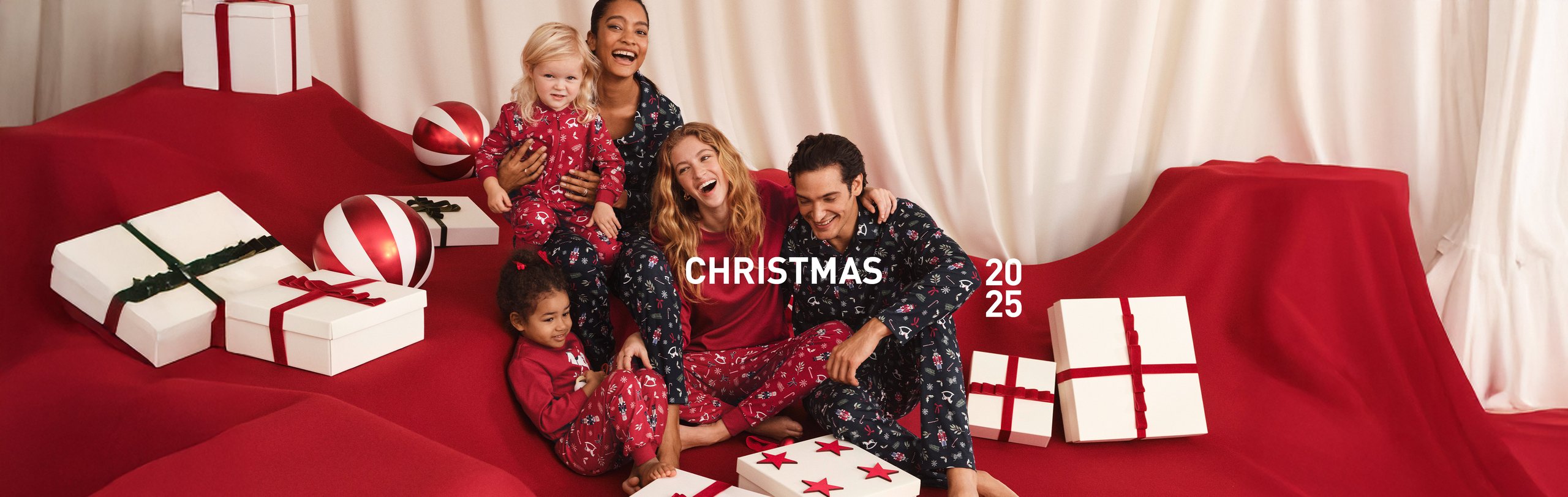 Damen, ein Herr und Kinder tragen die neue weihnachtliche Nachtwäsche in abgestimmten Mini-Me Styles.