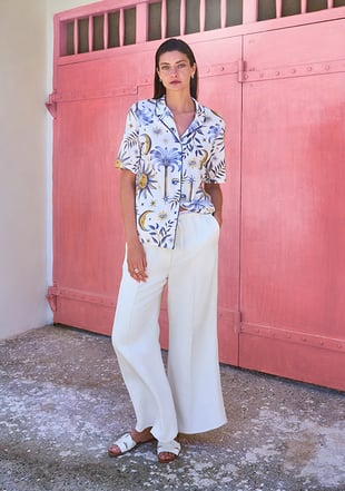 Dame trägt gemustertes Pyjama Oberteil mit mystische Symbolen kombiniert für den Alltag. 