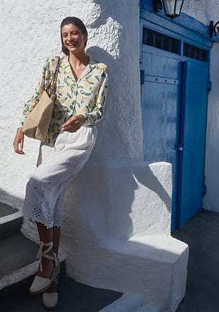 Dame trägt gemustertes Pyjama Oberteil mit Zitronen kombiniert für den Alltag. 