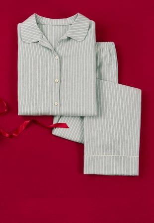 Classic pajamas with a fine stripe pattern in light blue, presented decoratively as a stylish gift idea for relaxed nights.