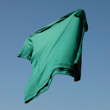 The image shows a green cooling nightwear top against a blue sky.