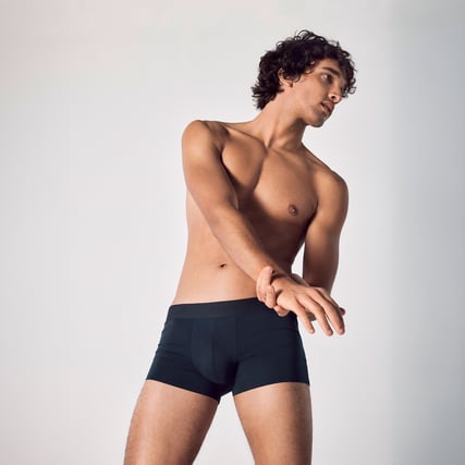 The model is wearing blue boxer shorts from CALIDA's Clean Line series. 