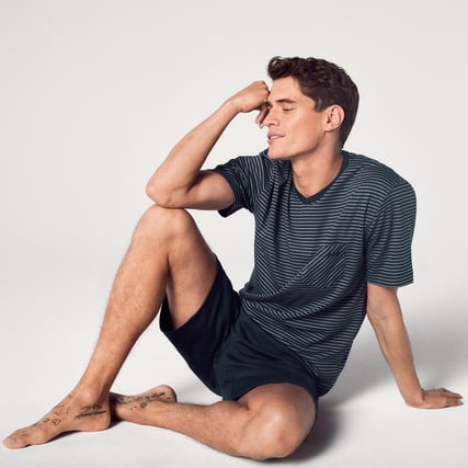 The model is wearing blue pyjamas from the CALIDA Relax Streamline range. 