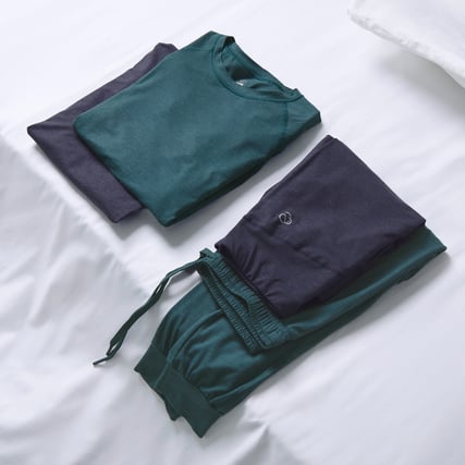 Das Bild zeigt ein dunkelblaues und dunkelgrünes Lounge-Set aus der Serie DSW Warming der Marke CALIDA. 