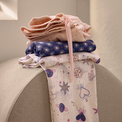 Das Bild zeigt eine rosane Hose, eine blau-bedruckte Hose und eine weisse Hose mit Motiv aus der Serie Favourites Universe der Marke CALIDA. 