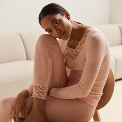 Das Model trägt einen rosanes Oberteil und eine rosane Leggings aus der Serie Silk Wool Joy der Marke CALIDA. 