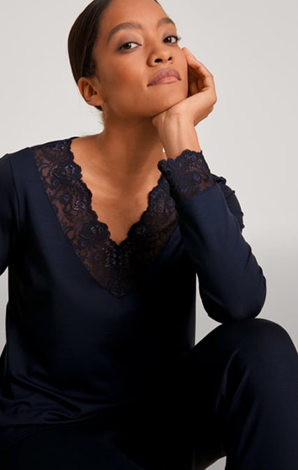 The lady is wearing a pair of breathable pyjamas from the Elegant Dreams range in blue.