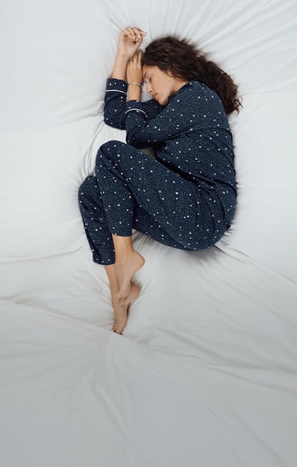 Dame trägt dunkelblaue Nachtwäsche mit Sternen-Print.