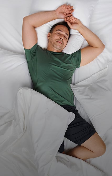 Mann trägt einen grünen, temperaturausgleichender Pyjama aus der Serie Deepsleepwear Balancing.