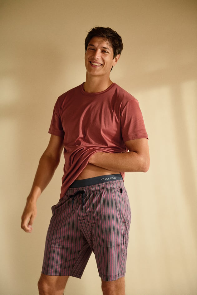 Pyjamas with sun print: A person is wearing dark pyjamas with a striking sun pattern in shades of yellow in a close-up.