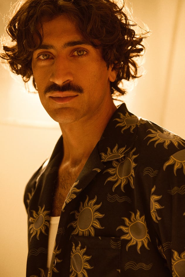 Pyjamas with sun print: A person is wearing dark pyjamas with a striking sun pattern in shades of yellow in a close-up.