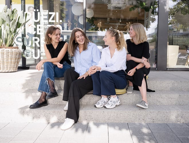 Four female employees sit in front of CALIDA Shop.