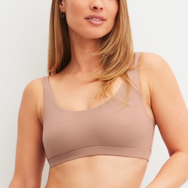 The model is wearing a bustier from the Natural Skin series in the color pink.