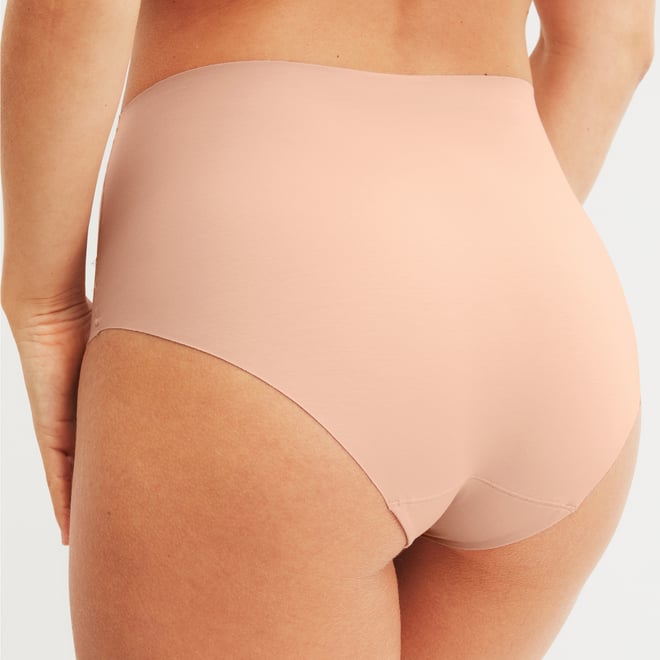 Frau trägt High Waist Slip in Nude mit hohem Bund und nahtloser Verarbeitung – Rückansicht