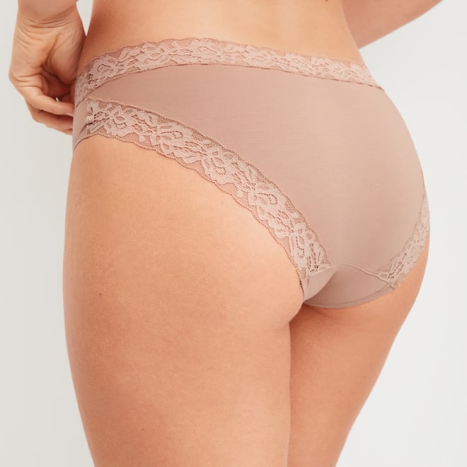 Frau trägt roséfarbenen Slip mit floraler Spitze an Bund und Beinabschluss – Detailaufnahme der Rückansicht