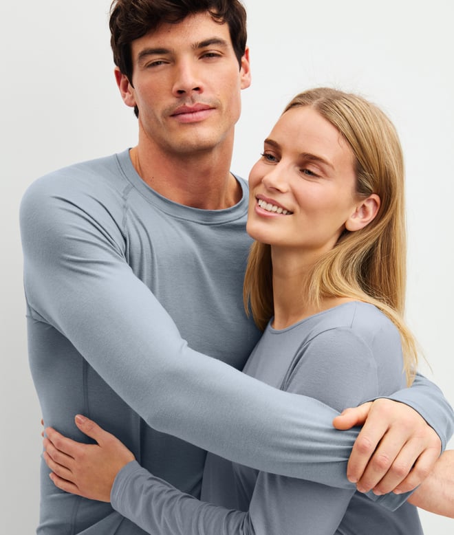 Eine Dame und ein Herr tragen Nachtwäsche der Deepsleepwear Warming Kollektion in hellblau.
