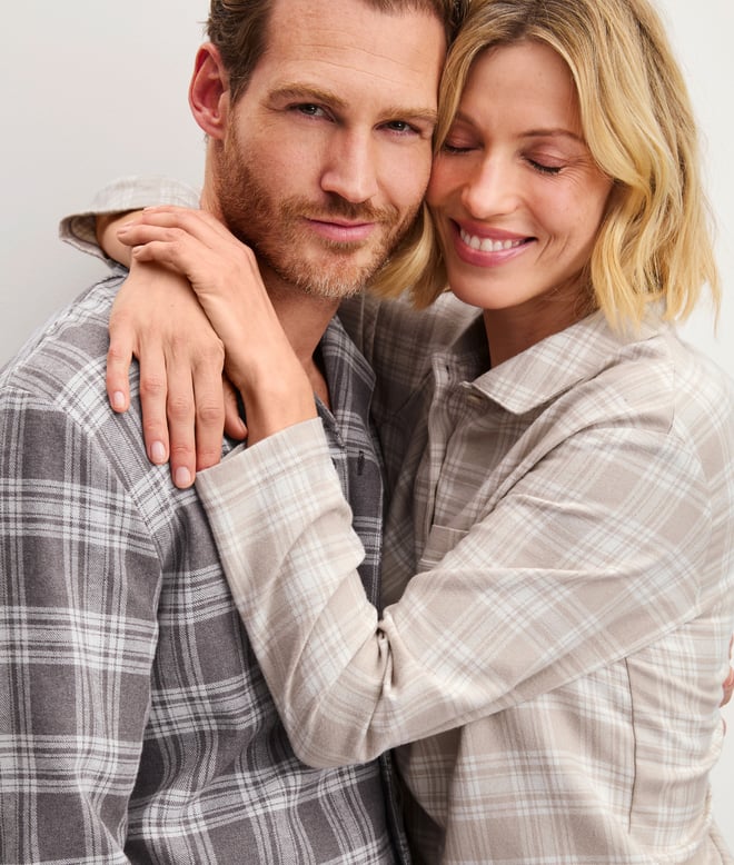 Die Dame und der Herr tragen karierte Flanell Pyjamas.