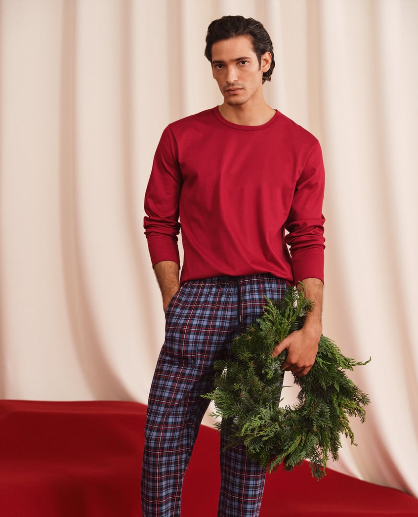 Ein Herr trägt die neue rot-blau-karierte Nachtwäsche der Serie Family & Friends.