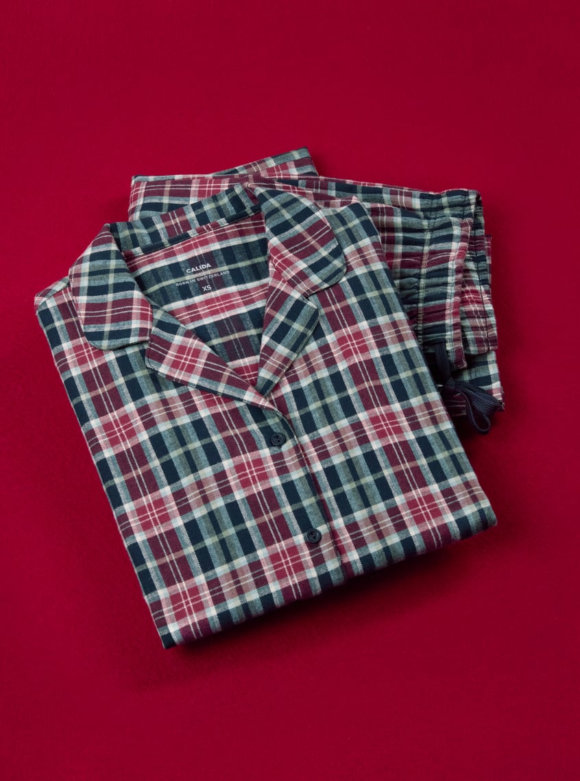 Classic pajamas with a checkered pattern in blue and burgundy tones, decoratively presented on a festive background.