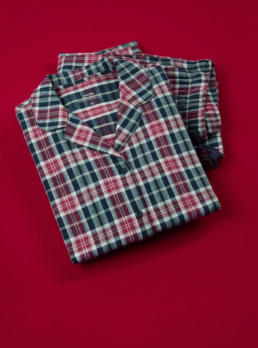 Classic pajamas with a checkered pattern in blue and burgundy tones, decoratively presented on a festive background.