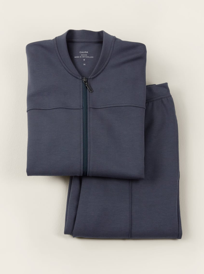 Comfortable homewear set in blue with zip-up jacket and matching pants, decoratively arranged as a gift idea.