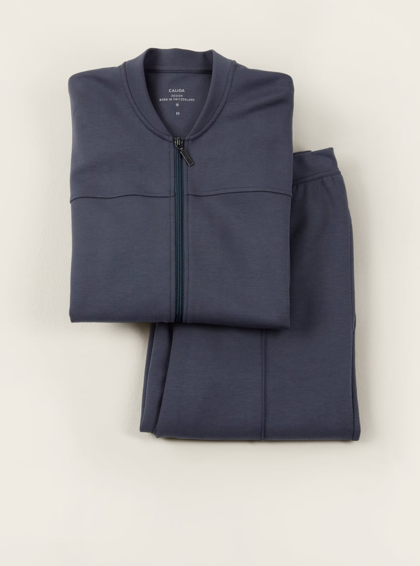Comfortable homewear set in blue with zip-up jacket and matching pants, decoratively arranged as a gift idea.
