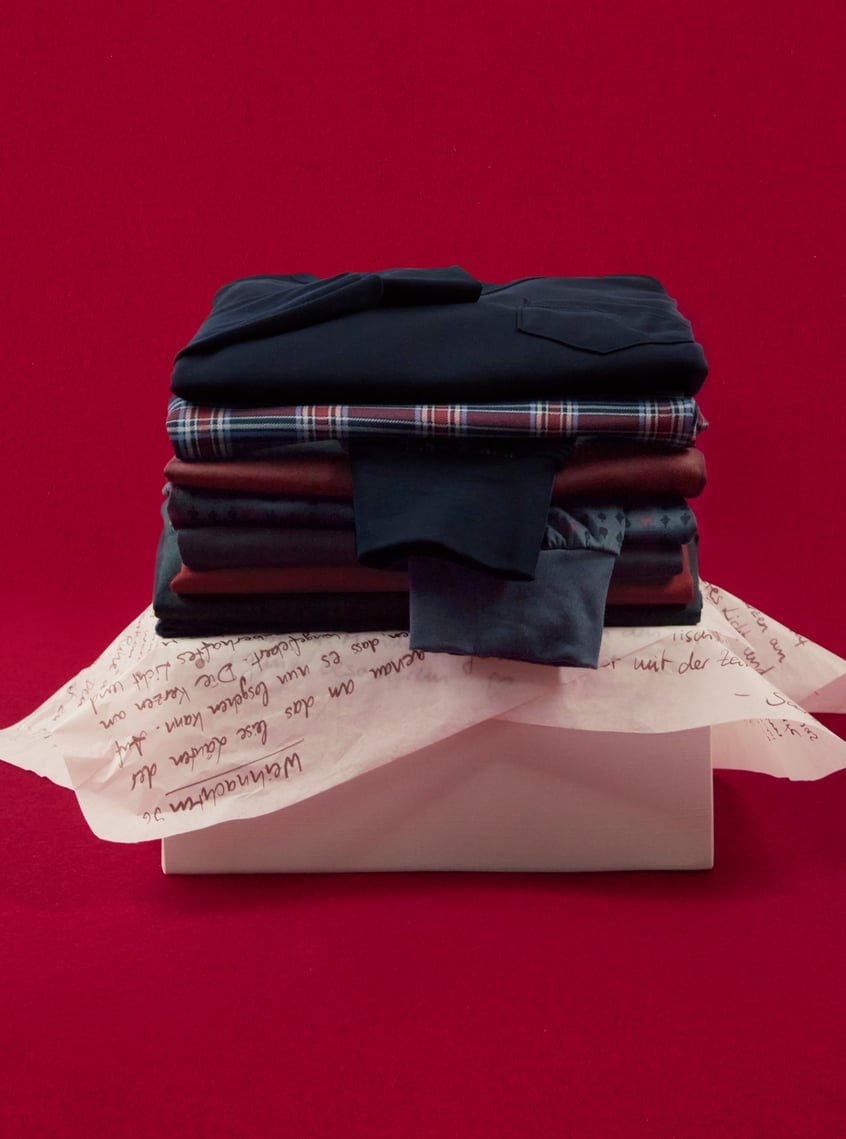 Selection of coordinated nightwear and loungewear sets, stacked and festively presented.