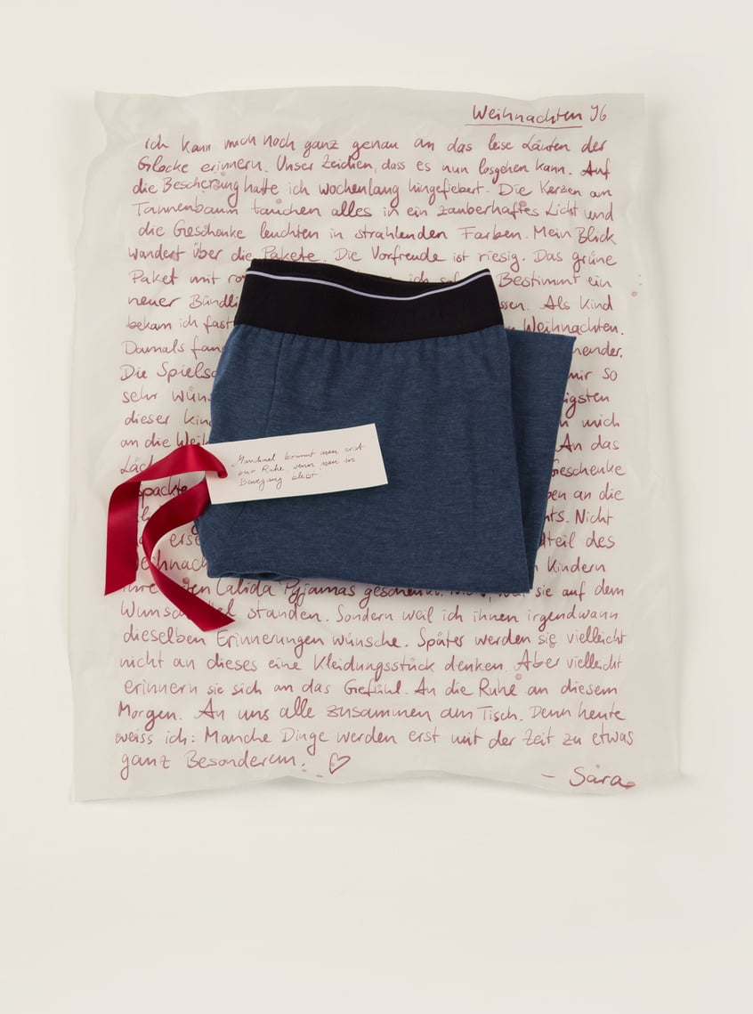 Warming men's underwear in blue with a wide comfort waistband, decoratively presented as a gift idea.