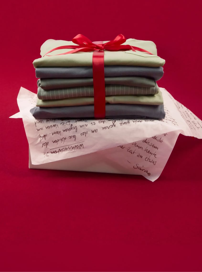 Selection of modern nightwear and loungewear styles, stacked and festively presented with ribbon.