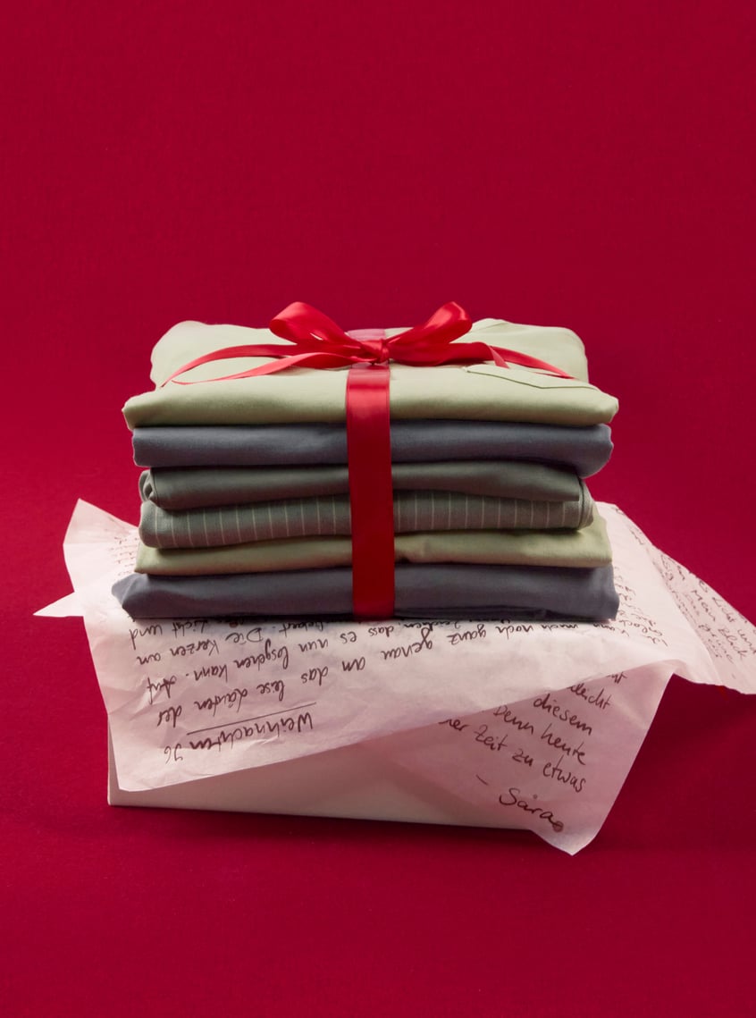 Selection of modern nightwear and loungewear styles, stacked and festively presented with ribbon.
