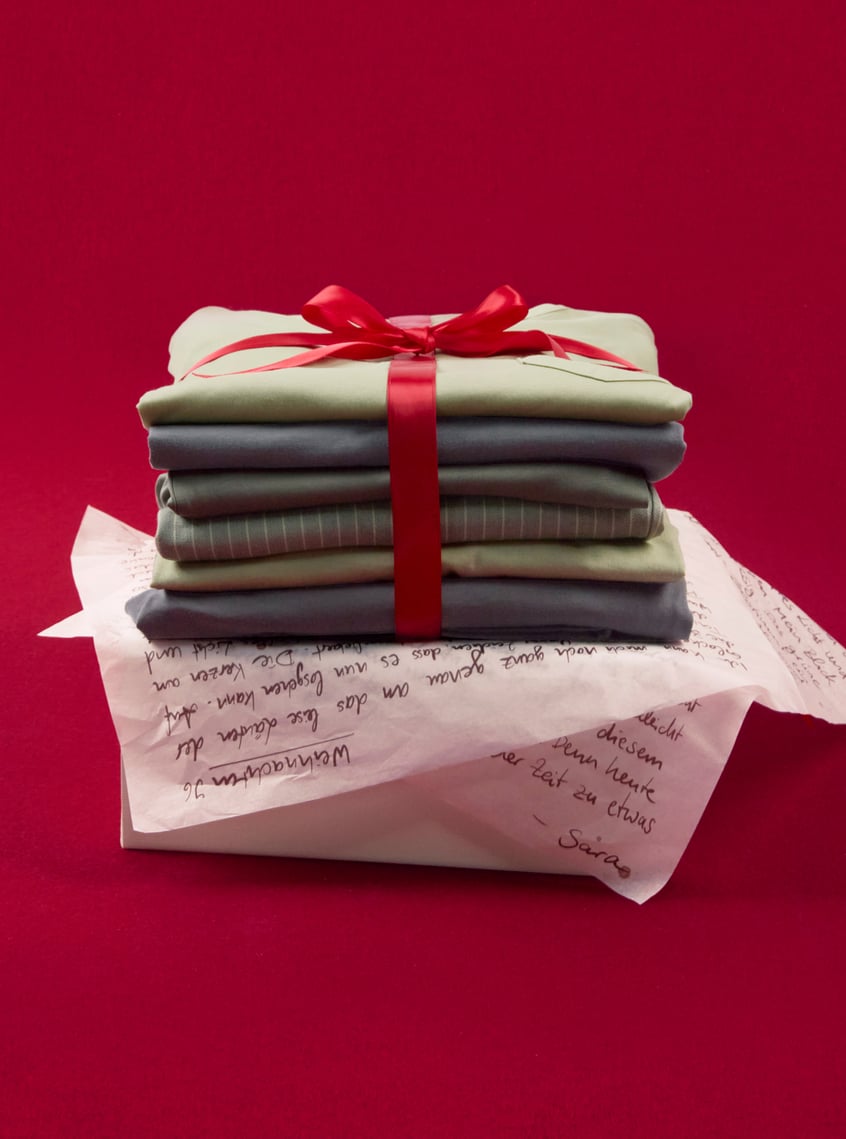 Selection of modern nightwear and loungewear styles, stacked and festively presented with ribbon.