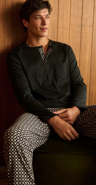 The man wears warming nightwear from the new Fall Winter collection in blue.